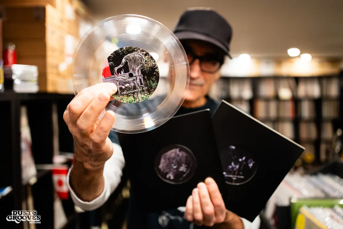 KEXP music director Kevin Cole in his home record basement in Seattle, pictured with shelves of vinyl and personal music memorabilia for Dust & Grooves Volume 2.