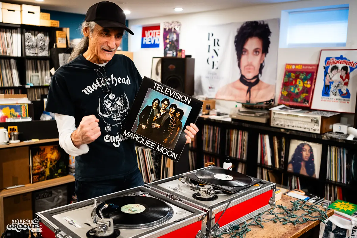 KEXP music director Kevin Cole in his home record basement in Seattle, pictured with shelves of vinyl and personal music memorabilia for Dust & Grooves Volume 2.