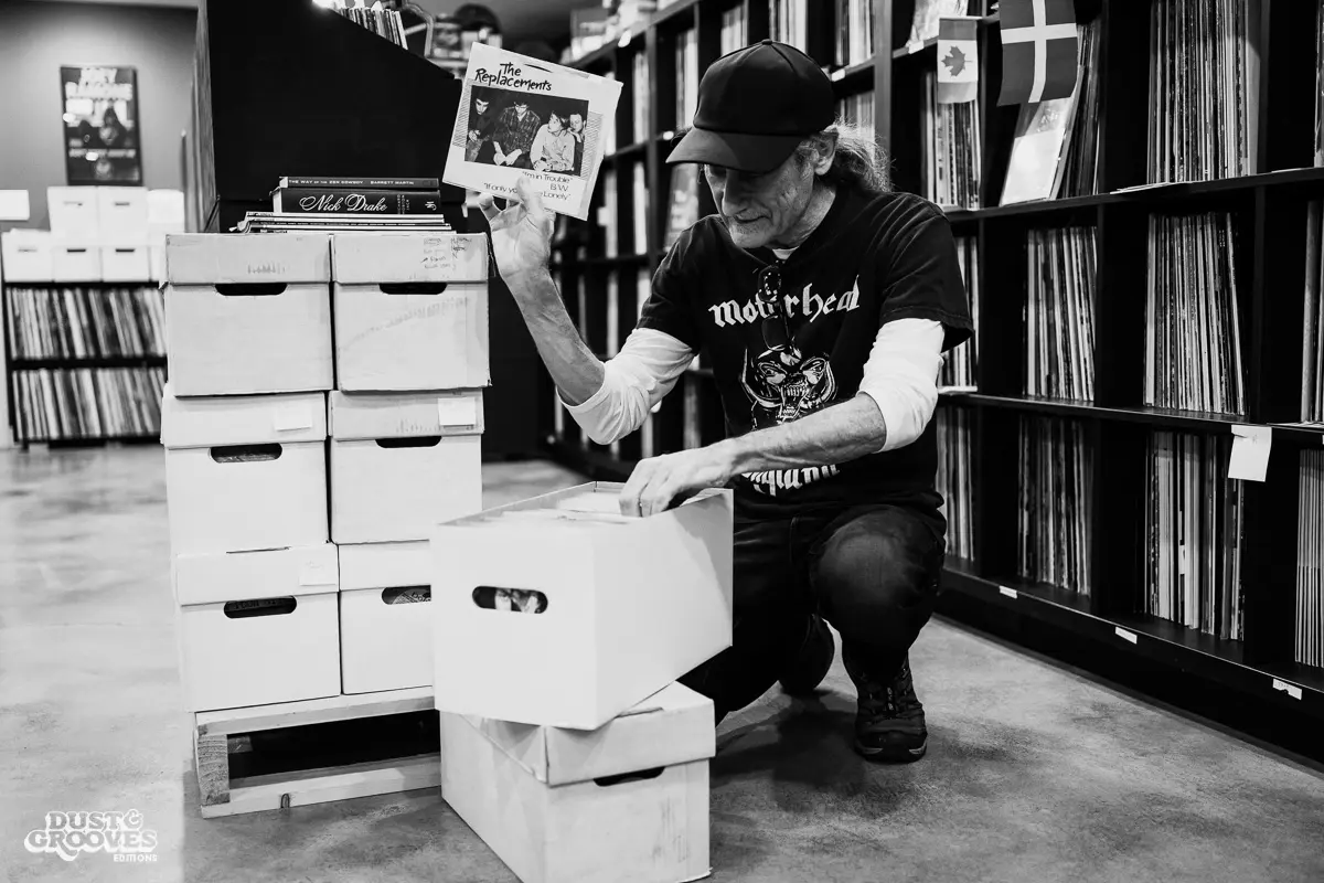 KEXP music director Kevin Cole in his home record basement in Seattle, pictured with shelves of vinyl and personal music memorabilia for Dust & Grooves Volume 2.