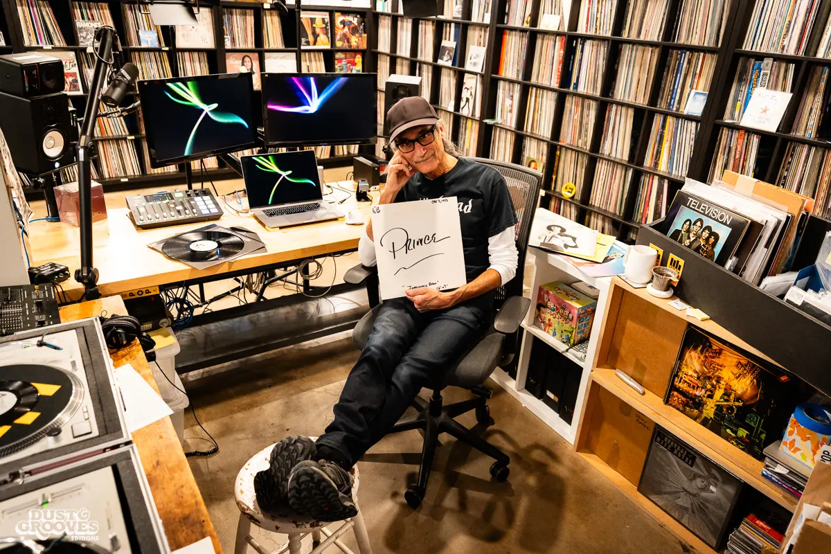 KEXP music director Kevin Cole in his home record basement in Seattle, pictured with shelves of vinyl and personal music memorabilia for Dust & Grooves Volume 2.