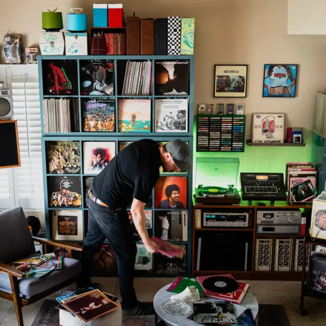 DJ Platurn, a music producer and vinyl record collector, is pictured in his Vallejo, CA home with shelves of vinyl and personal music memorabilia for Dust & Grooves Volume 2.